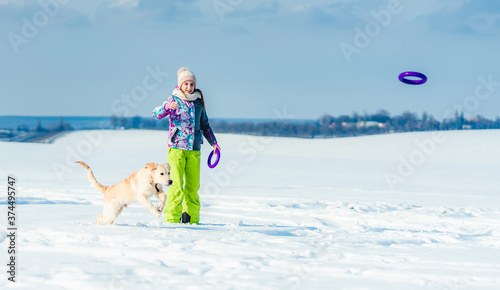 Girl running with dog in snow