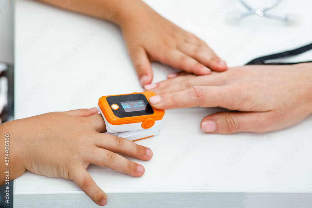 Pulse oximeter measure pulse rate and oxygen, on child's finger close-up Pulse oximeter measure pulse rate and oxygen, on child's finger close-up