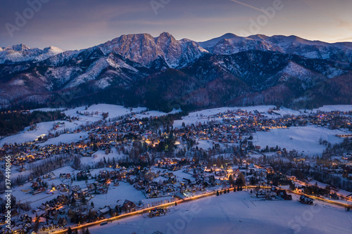 Illuminated Zakopane city in winter after dusk, aerial view