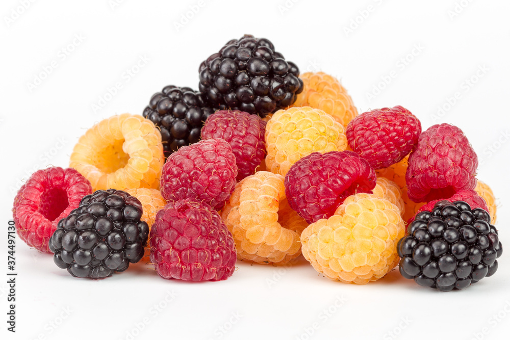 Lot of organic red and yellow raspberries and black blackberries on white background. Selective focus Lot of organic red and yellow raspberries and black blackberries on white background. Selective focus