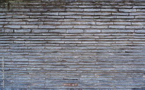 Stone brick wall, damaged and natural stone wall for vintage background and design _ 石調レンガ壁