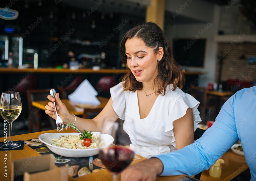 Loving couple eating together at restaurant.