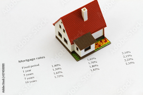 Interest rates written on white piece of paper with EUR banknotes and coins 