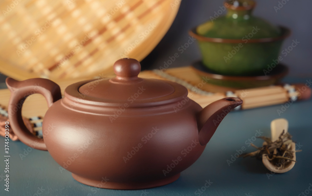 Chinese clay teapot, traditional porcelain teacup and tea ceremony items on blue table