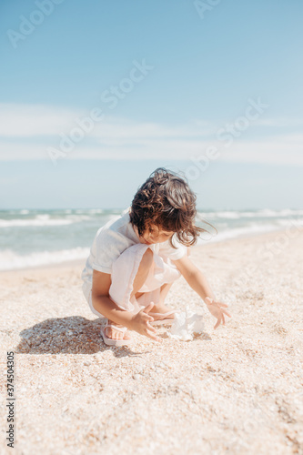 Curly young toddler girl with seashell