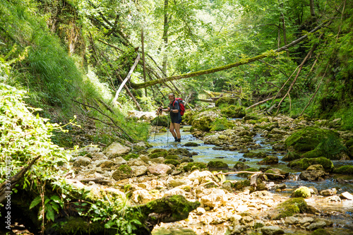Adult hiker with a backpack on an adventurous hike through the canyon of the river Gačnik, Soca valley, Slovenia, Europe