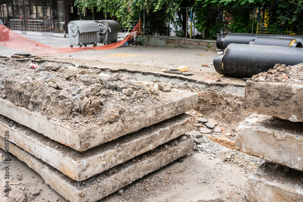 Insulated huge pipes and concrete slabs on city road. Insulated huge pipes and concrete slabs on city road.