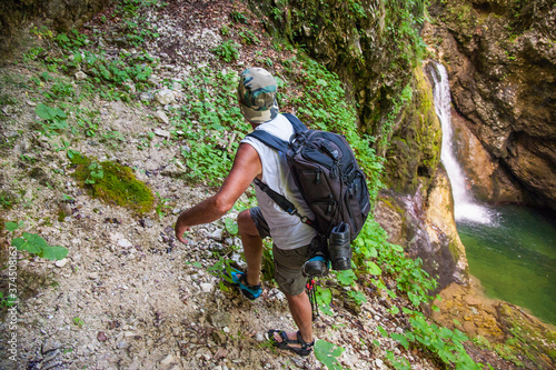 Adult hiker with a backpack on an adventurous hike through the canyon of the river Gačnik, Soca valley, Slovenia, Europe.