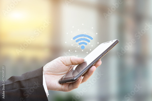 Canvas-taulu Hand holding using mobile smartphone with wifi icon