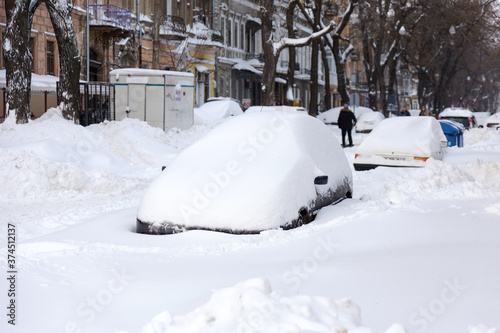 Odessa, Ukraine - January 01, 2015: Snow drifts in the city on a winter frosty day. Car blocked in the yard by snowdrifts after the heavy snow storm © Elena