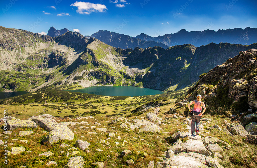 Tourist and hiker on trail in high mountains .  Activity in alpine style scenery. High mountain lanscape in  Europe. Tatras in summer.