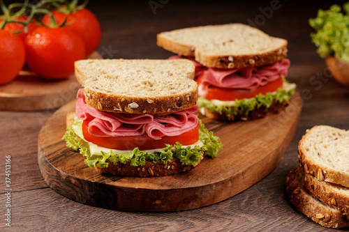 Whole grain bread sandwich with salami, tomato, cheese and fresh lettuce