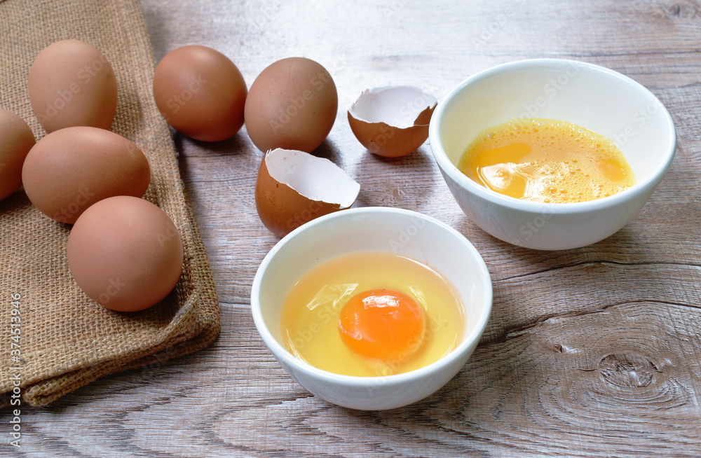 raw egg yolk in cup and crack brown shell on table raw egg yolk in cup and crack brown shell on table