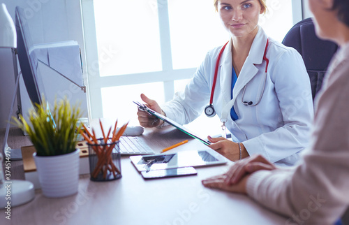 Woman doctor showing a bottle of pills to the patient