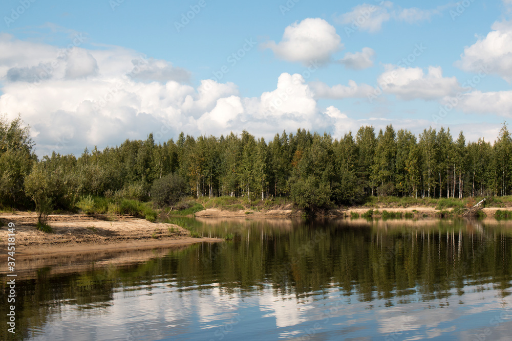 Forest lake view, smooth surface of a lake with clouds reflected, shining level of a forest lake