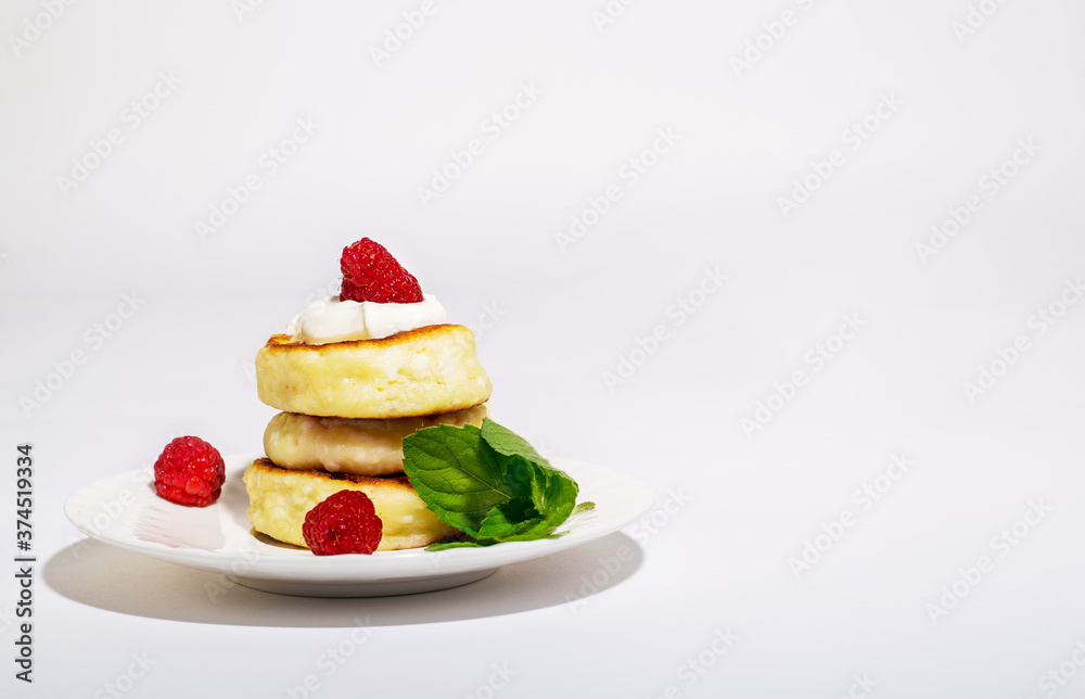 Delicious and healthy cheesecakes with sour cream and raspberries, with a Cup of black coffee. 