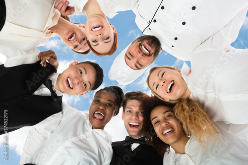 Obraz na plátně Smiling Restaurant Staff Standing Against White Background