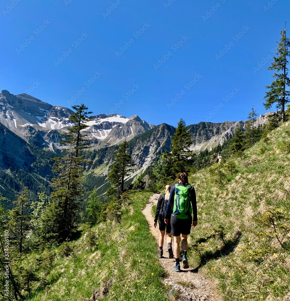 Women hiking in alps, mountain view with blue sky, Bavaria, Germany