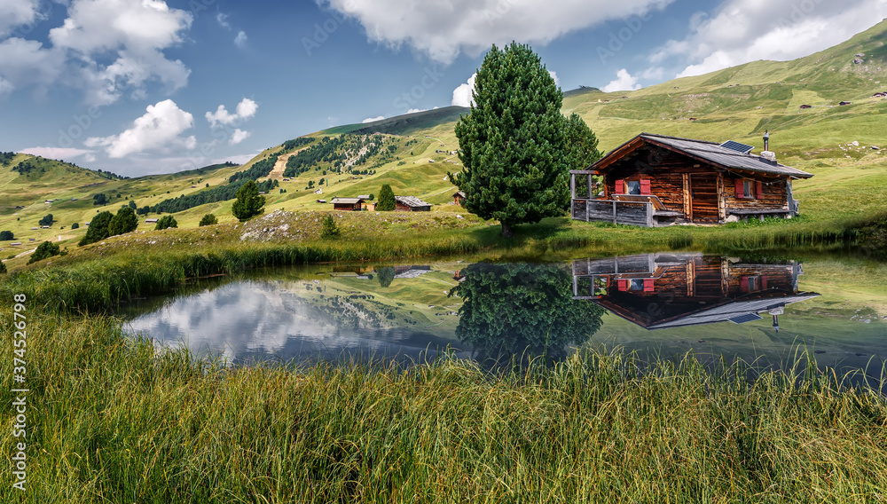 Fabulous Mountain scenery in summer. Photo of wooden house on the shore of the lake, under sunlit on highland. Amazing nature landscape. Picture of wild area. concept of Travel and holiday on nature