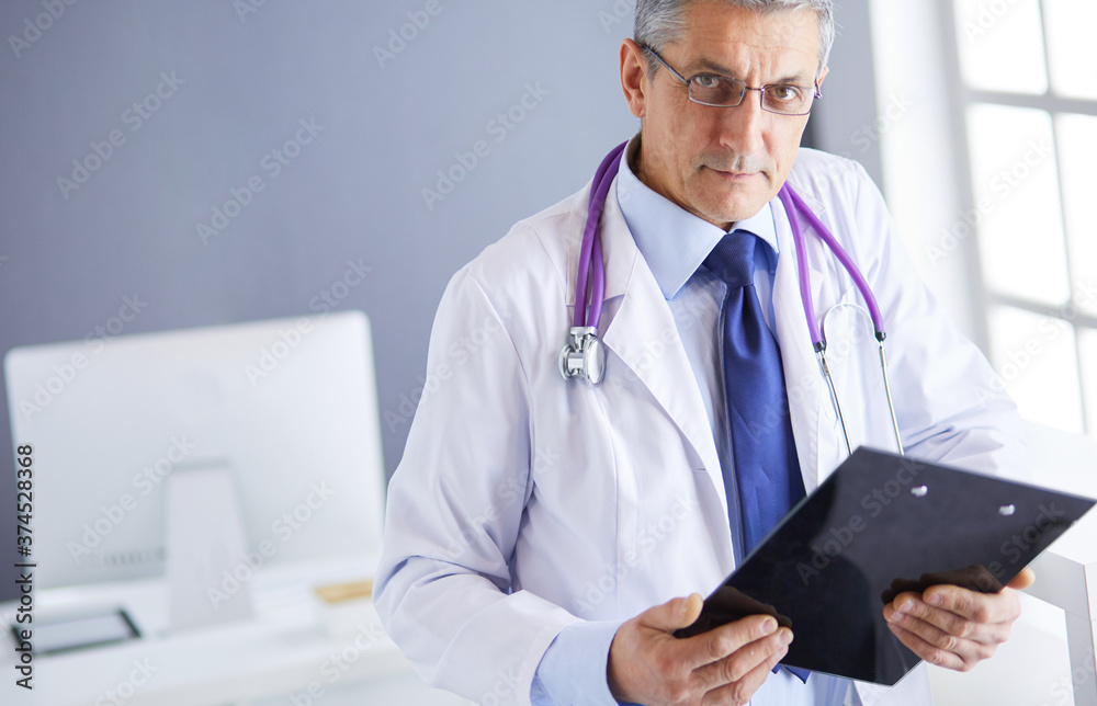 Male doctor writes notes on the clipboard in the hospital Male doctor writes notes on the clipboard in the hospital