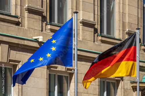 Flaggen von Deutschland und der Europäischen Union wehen im Wind in Berlin. 