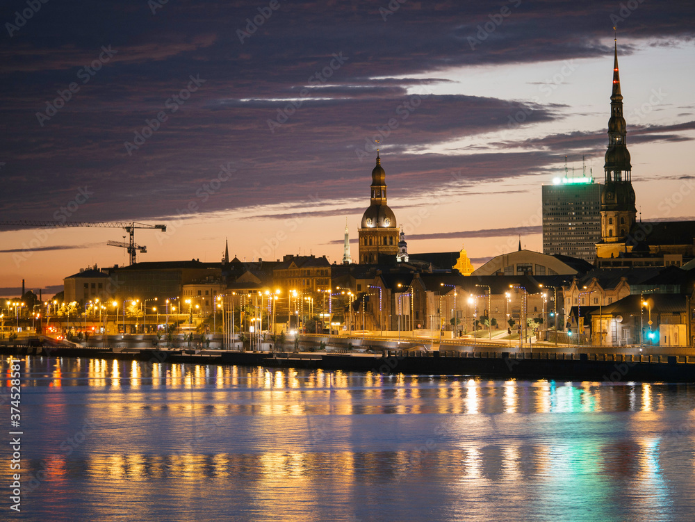 Naklejka premium Long exposure night cityscape in Riga, Latvia with reflections over water