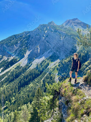 Woman looking over valley in alps, mountain view with blue sky, Bavaria, Germany