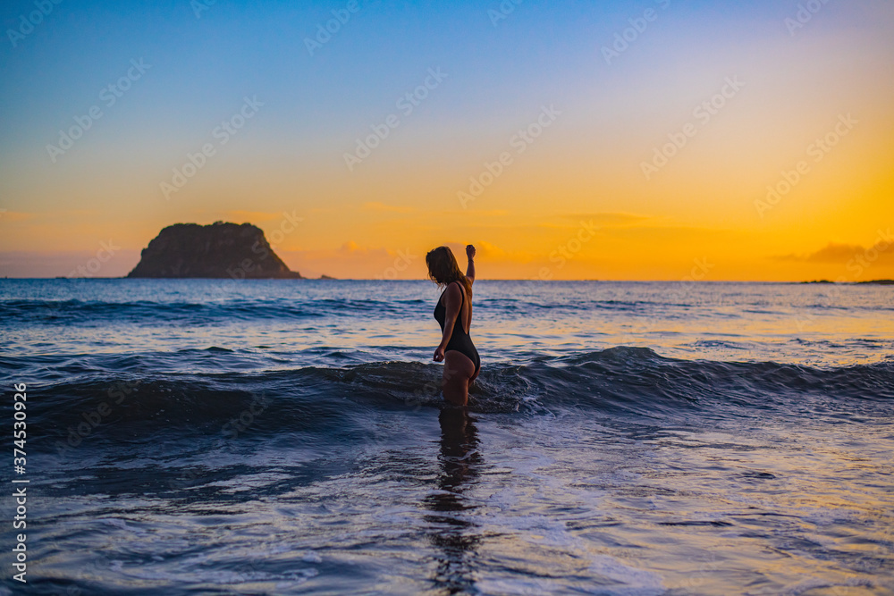 young woman on the beach at sunrise