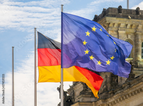 Flaggen von Deutschland und der Europäischen Union wehen im Wind vor dem Reichstag in Berlin.  photo