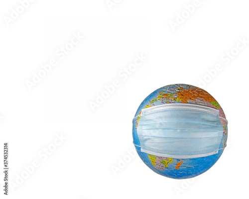 Surgical face mask putting on a world globe protecting the world from pollution and infectious diseases  closeup  objects isolated on a white background template  with copy space 