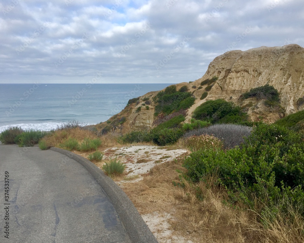 Walking down the paved path to San Clemente State Beach, from the bluffs, on a peaceful morning, in Orange County. San Clemente State Beach is a popular campground for families with is sandy beach. Walking down the paved path to San Clemente State Beach, from the bluffs, on a peaceful morning, in Orange County. San Clemente State Beach is a popular campground for families with is sandy beach.