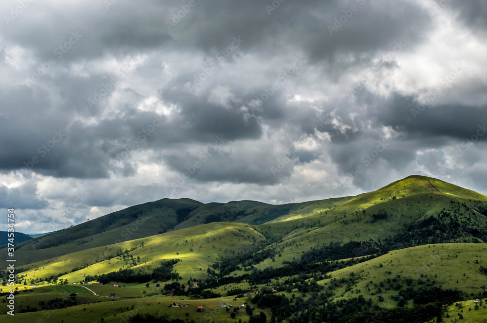 The landscape of Zlatibor Mountain in Serbia. Green meadows and hills under the blue sky with clouds in the summertime