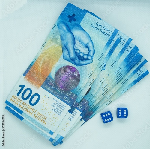 Shot from above of dices next to Swiss franc bills with a white background © Swiss Stock Photo