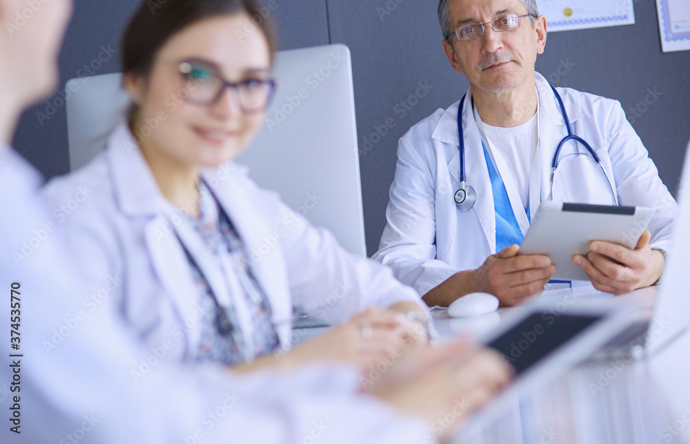 Serious medical team using a laptop in a bright office Serious medical team using a laptop in a bright office