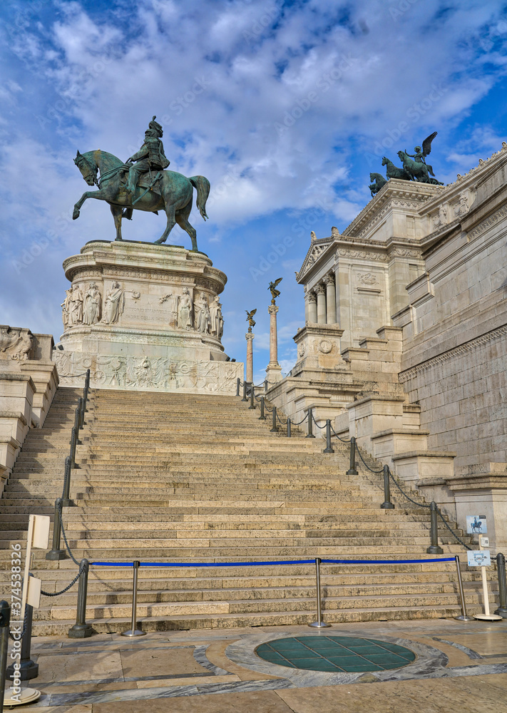 Obraz premium At the top of a large stone staircase, Victor Emmanuel II rides on a horse at the Victor Emmanuel II National Monument in Rome, Italy. 