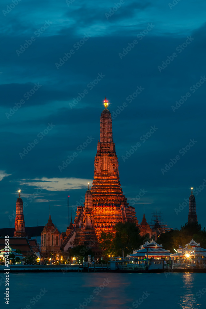 Beautiful vertical view of famous Wat Arun, the Buddhist temple of dawn, in the light of the blue hour after sunset, Bangkok, Thailand
