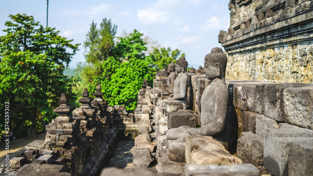 Statue of sitting buddha at Borobudur Temple, spiritual stone sculpture, UNESCO world heritage site Statue of sitting buddha at Borobudur Temple, spiritual stone sculpture, UNESCO world heritage site