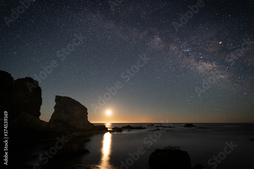 Night landscape with Moon and Milky Way on the coast of the Escullos. Natural Park of Cabo de Gata. Spain.