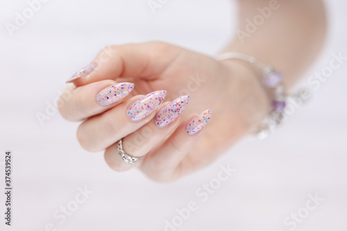Canvas-taulu Woman's hands with long nails and pink fuchsia bottle manicure with nail polish