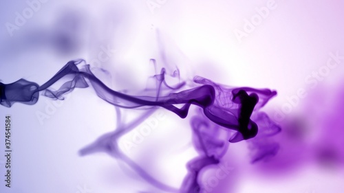 Isolated Purple Violet Ink Cloud floating in clear water. Shot on White Background with selective focus.