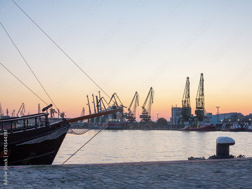 Varna, Bulgaria - July 23, 2016: View on seaport with cranes, cargo and passenger ships at sunset, Varna.