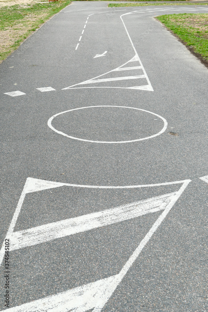 Ground marking with white paint. Driving track for bike or motorcycle. Road with direction symbol.