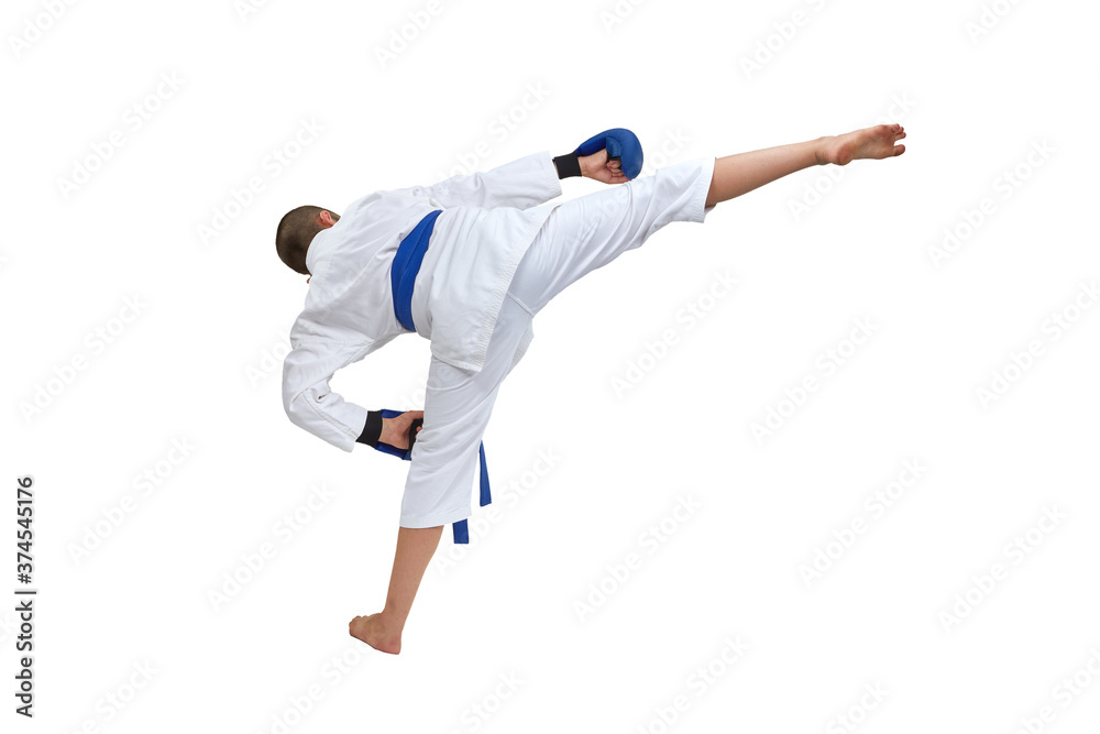 On white isolated background in karategi boy athlete trains kick On white isolated background in karategi boy athlete trains kick