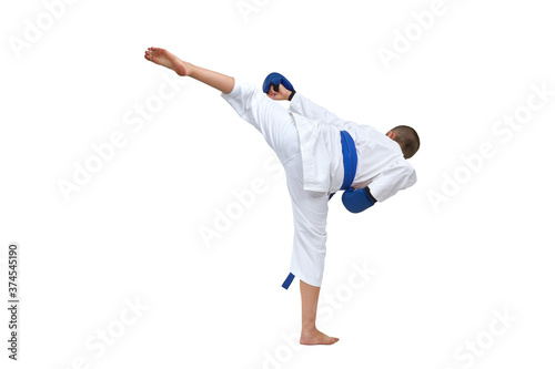 Athlete in karategi with blue belt beats kick kick on white isolated background