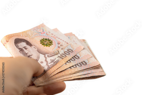 Hand holding Thai currency,...