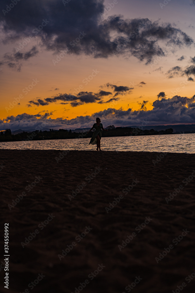 woman walking on the beach at sunset