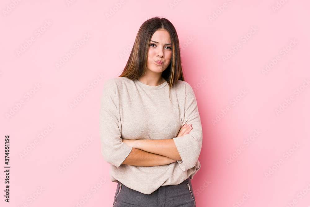 Fototapeta premium Young caucasian woman posing isolated blows cheeks, has tired expression. Facial expression concept.