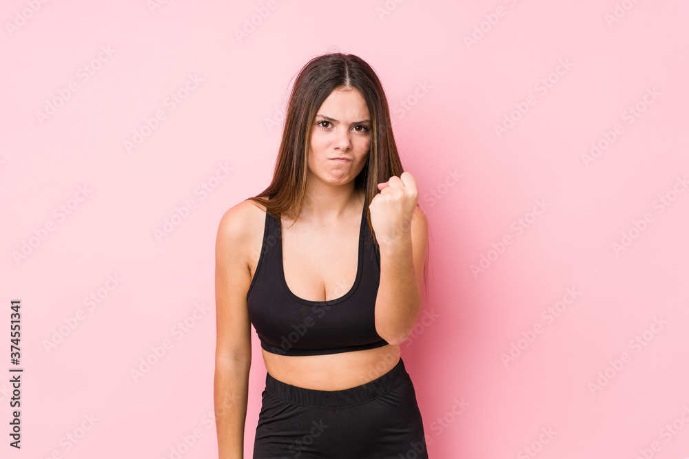 Young fitness caucasian woman isolated showing fist to camera, aggressive facial expression. Young fitness caucasian woman isolated showing fist to camera, aggressive facial expression.