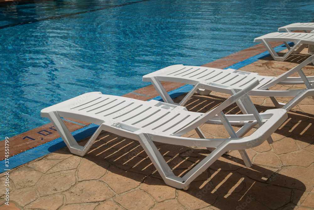 empty beach chairs by the pool empty beach chairs by the pool
