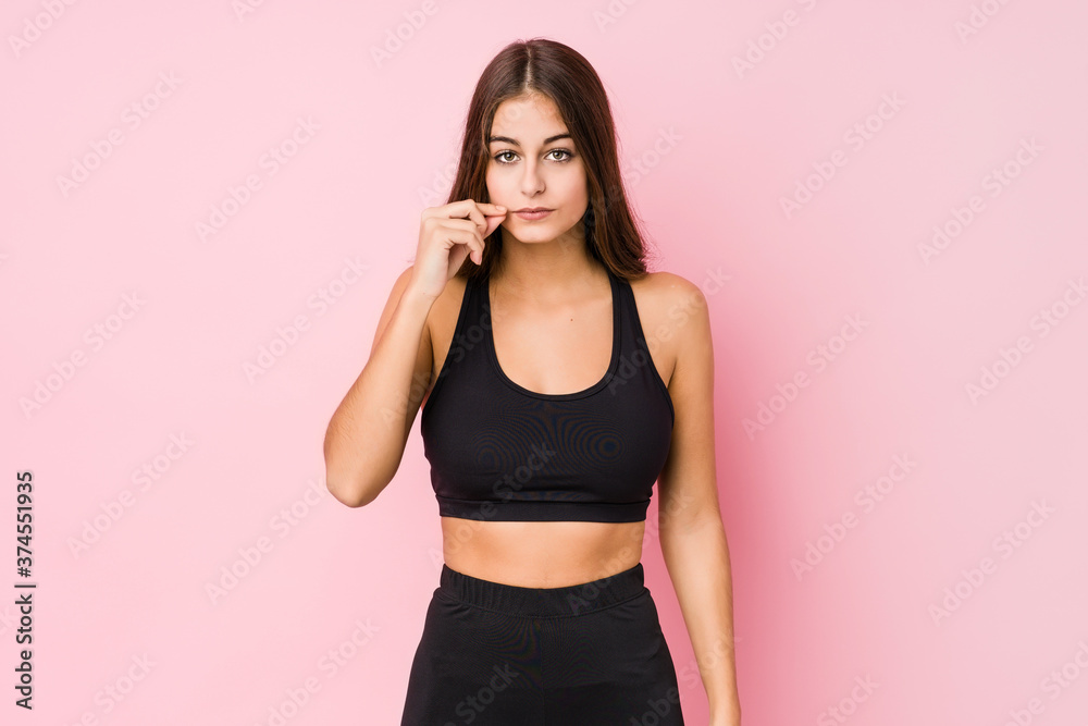 Young caucasian fitness woman doing sport isolated with fingers on lips keeping a secret. Young caucasian fitness woman doing sport isolated with fingers on lips keeping a secret.